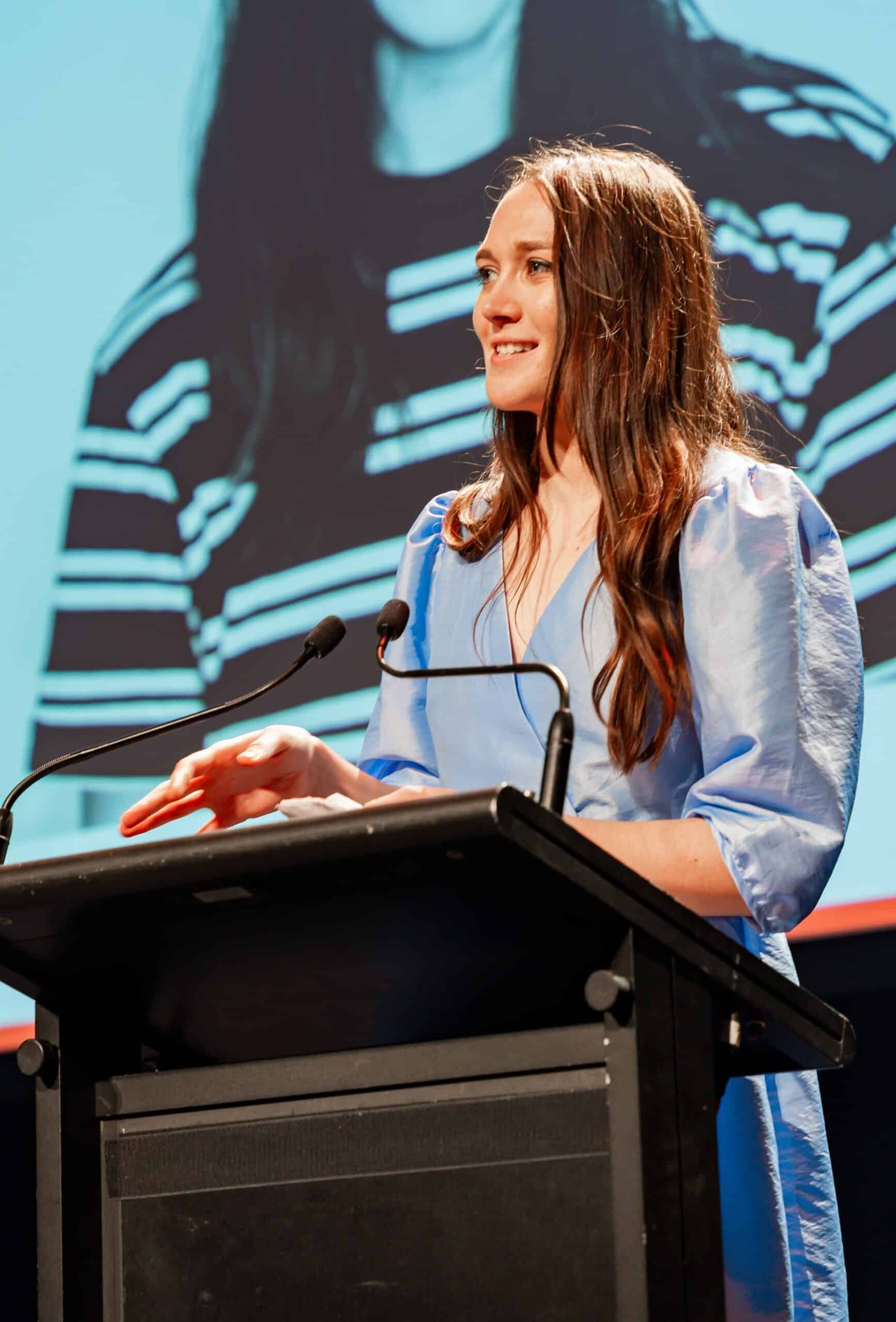 A woman addressing an audience with a speech at a corporate event in Melbourne