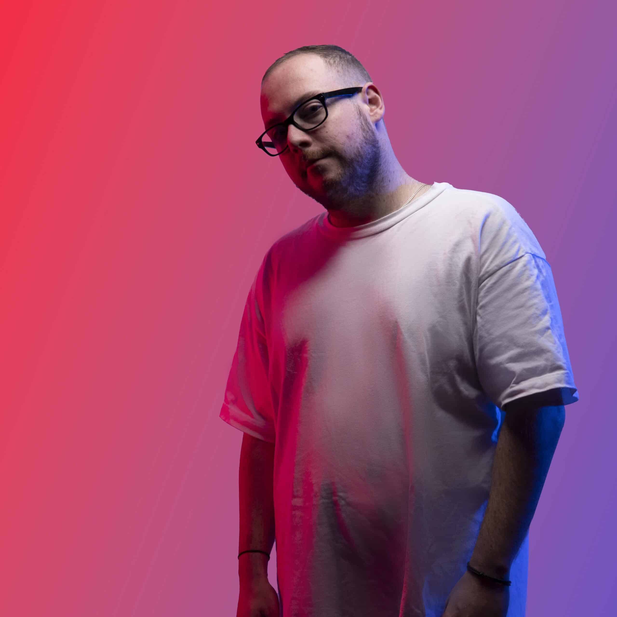 A man in glasses standing in front of a red and blue background. Professional Headshot Photography Melbourne, Crayluxmedia